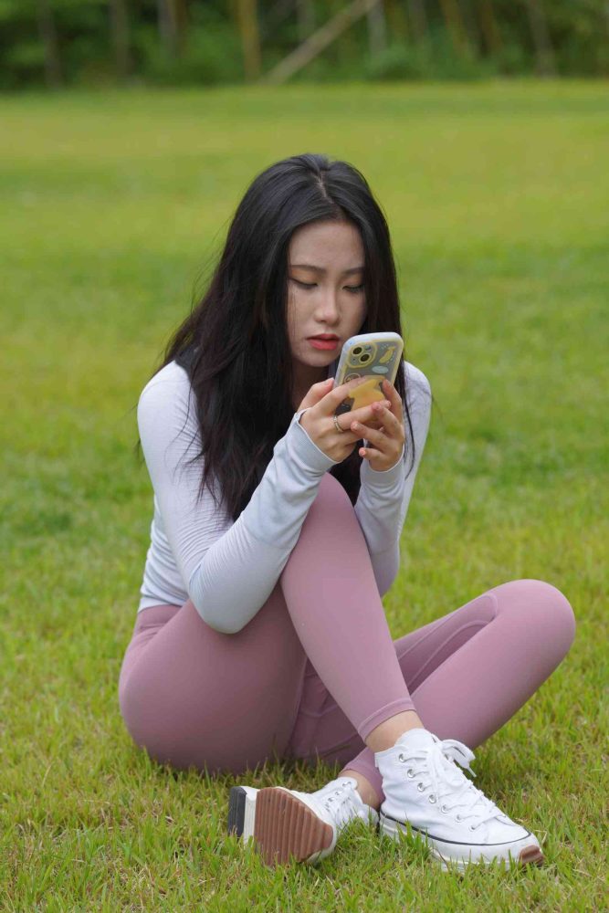 图片[1]-坐在草地玩手机的瑜伽姑娘【733P】04012-西哈图库